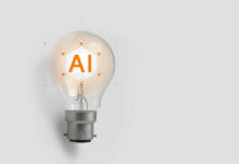 AI Firms Hit With 50% Grab? Lightbulb with AI text and digital lines