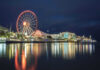 VIDEO: Festival Turns Into Deadly War Zone Ferris wheel and waterfront lights reflecting on water.