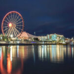 VIDEO: Festival Turns Into Deadly War Zone Ferris wheel and waterfront lights reflecting on water.