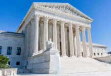 Supreme Court building with columns, fountain, and statue.