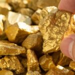 VIDEO: Gold Pit Gives Way — Deadly Horror Underground Hand holding a rough gold nugget among scattered gold pieces