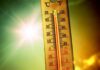 Hottest Month Ever Hits America Thermometer displaying high temperature against a bright sun