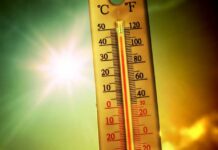 Hottest Month Ever Hits America Thermometer displaying high temperature against a bright sun