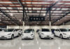 Tesla Hit — Massive Recall White Tesla cars displayed in showroom with Tesla sign.