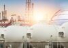 Trump Targets Big Oil Windfall Gas storage tanks in an industrial facility during sunrise
