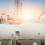 Trump Targets Big Oil Windfall Gas storage tanks in an industrial facility during sunrise