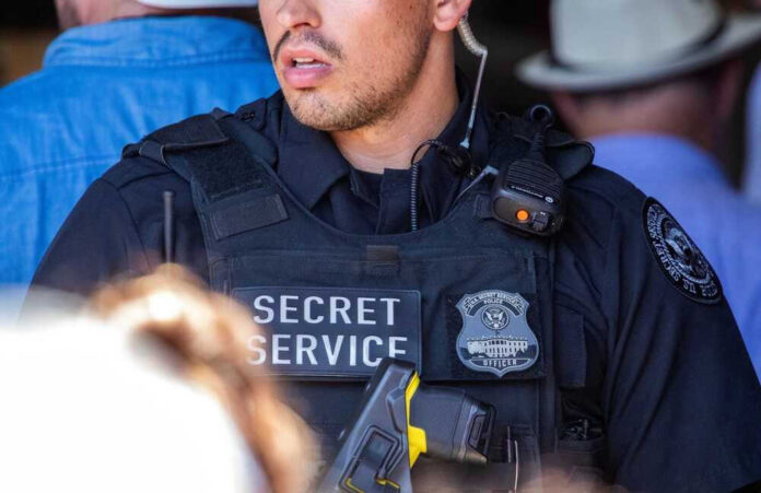 shutterstock_2346861587 Secret Service officer in uniform with equipment visible.