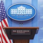 Sudden Exit From The Podium White House press briefing podium with microphones and U.S. flag