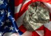 Camouflage military cap resting on an American flag