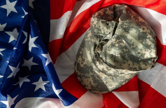 Us,Army,Helmet,And,Dog,Tag,On,Us,Flag,Background Camouflage military cap resting on an American flag