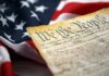 Fifth Amendment Firestorm Engulfs Fauci Close-up of a historical document with the American flag in the background