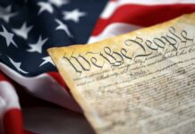 Fifth Amendment Firestorm Engulfs Fauci Close-up of a historical document with the American flag in the background