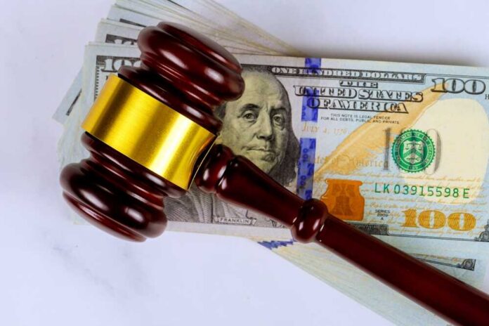 Wooden,Justice,Gavel,Lies,On,Top,Of,Pile,Of,Us Judge’s gavel on a stack of U.S. hundred-dollar bills