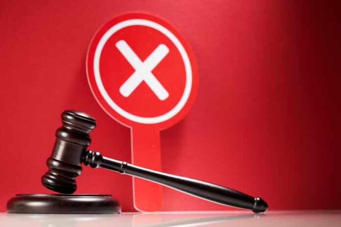 Wooden,Gavel,And,Cross,Mark,On,Red,Background.