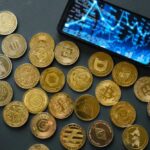 Bitcoin Vaults Cracked — Millions Vanish Various cryptocurrency coins scattered around a smartphone displaying market data