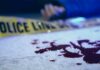 Officer Down, Wife Vanishes — Then This! Blood on pavement with police tape and a hand in the background