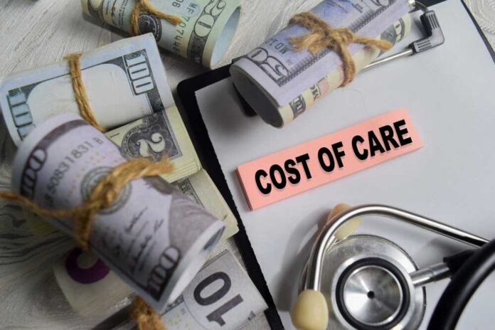 Concept,Of,Cost,Of,Care,Write,On,Sticky,Notes,Isolated Bundles of cash next to a stethoscope and a note that says 'COST OF CARE'