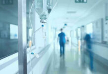 Fastest Ebola Outbreak Ever Hospital corridor with IV drip and healthcare worker.