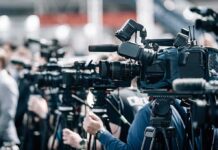 Diesel Panic Nears 2022 Peak Broadcast cameras on tripods at a press event