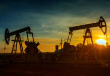 Trump’s Oil Bet Grows Even Bigger Oil pumpjacks silhouetted at sunset on a rural field