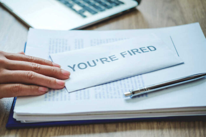 Boss,Send,A,Resignation,Letter,To,Business,Man,Stressing,For A hand resting on an envelope labeled 'YOU'RE FIRED' on a desk with papers and a pen