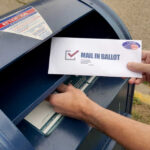Mail Ballot Brawl Hits A Supreme Wall Hands mailing a ballot envelope into a blue mailbox