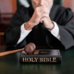 Holdout Bombshell Shadows Clancy Mistrial A judge in a courtroom with a gavel and a Holy Bible on the table
