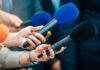 Impeach The Pentagon Chief? Reporters holding colorful microphones