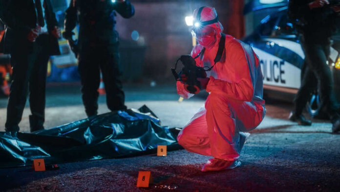 shutterstock_2230645973-1 Forensic investigator examines crime scene at night.