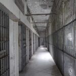 Convicted Killer Flip-Flops: Innocent Now? Empty prison corridor with barred cells on either side