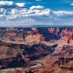 Canyon Horror: Human Remains Surface A panoramic view of the Grand Canyon with a river winding through the landscape