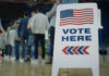 Rural Jitters: Trump’s Base Wobbles? People in line next to Vote Here sign
