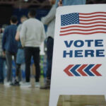 Rural Jitters: Trump’s Base Wobbles? People in line next to Vote Here sign