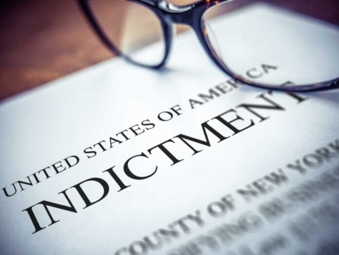 Close-up of an indictment document with glasses resting on it