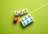 Massive Purge: Stars On The Chopping Block Colorful dice representing business roles and a scissors icon on a green background