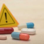 Blood Pressure Pills Fail – Nationwide Recall Pills with warning sign in background