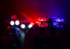 Killing Cop Charged Police car lights shining in the dark.