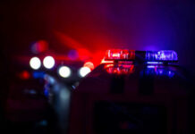 Killing Cop Charged Police car lights shining in the dark.
