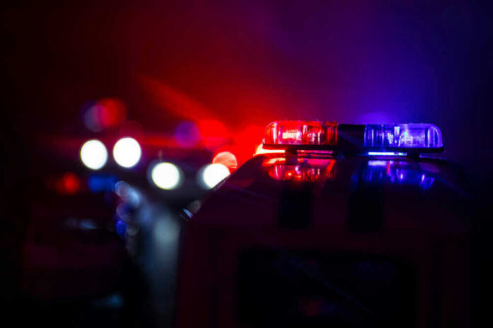 shutterstock_1191163906-1 Police car lights shining in the dark.