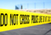 UPDATE: Church Massacre Horror Police do not cross tape stretched across an outdoor scene