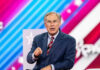 Texas Bombshell: Abbott Suddenly On The Ropes Greg Abbott speaking on stage in a blue suit and red striped tie