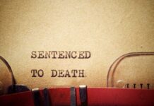Firing Squad Returns – Date Locked Typewriter typing the phrase 'Sentenced to Death' on aged paper