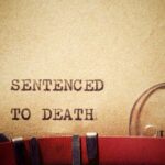 Execution Of Killer Fails Typewriter typing the phrase 'Sentenced to Death' on aged paper