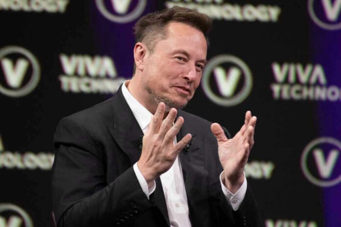 shutterstock_2318800315 Elon Musk speaking on stage with hands raised during a talk