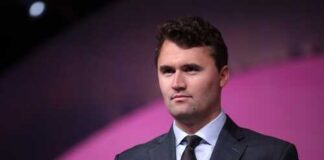 man in a suit speaking at a podium