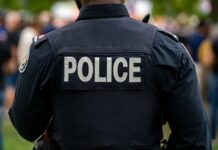 Morning Invasion Turns Deadly Back view of a police officer wearing a uniform with 'POLICE' displayed